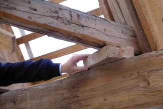 In Teilen des Dachstuhls liegen die Zargen auch gar nicht mehr auf den Mittelpfetten auf. Um die Gewichstübertragung trotzdem zu gewährleisten, wurde schon vor vielen Jahren Ziegelsteine zwischen das Holz gelegt.
